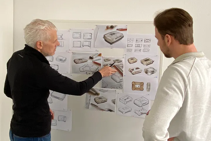 Mitarbeiter besprechen Produktdesign an Whiteboard