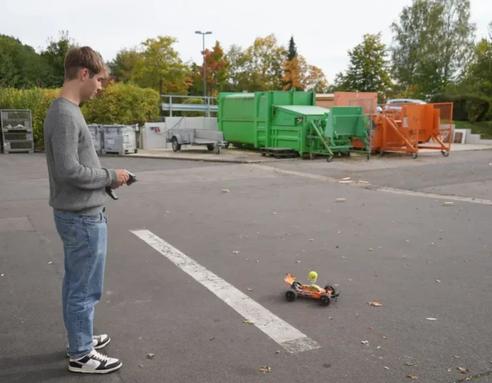 Schüler fährt einen Parcours mit einem kleinen Rennauto