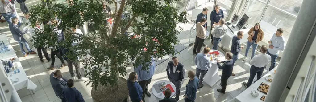 Kunden und Kundinnen tauschen sich mit H+K Mitarbeitenden im Foyer aus